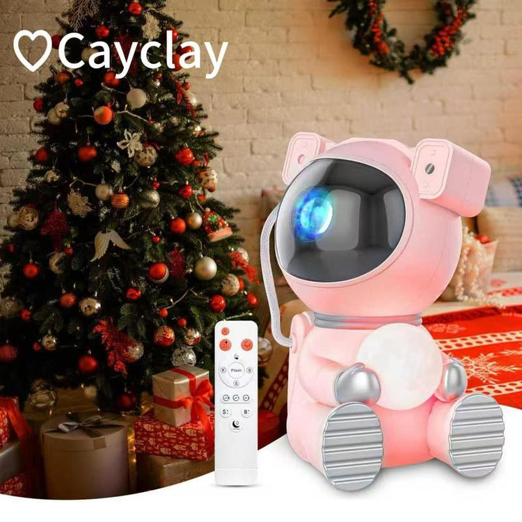 Astronaut Galaxy Projector with colorful nebula effects and remote control near a Christmas tree.