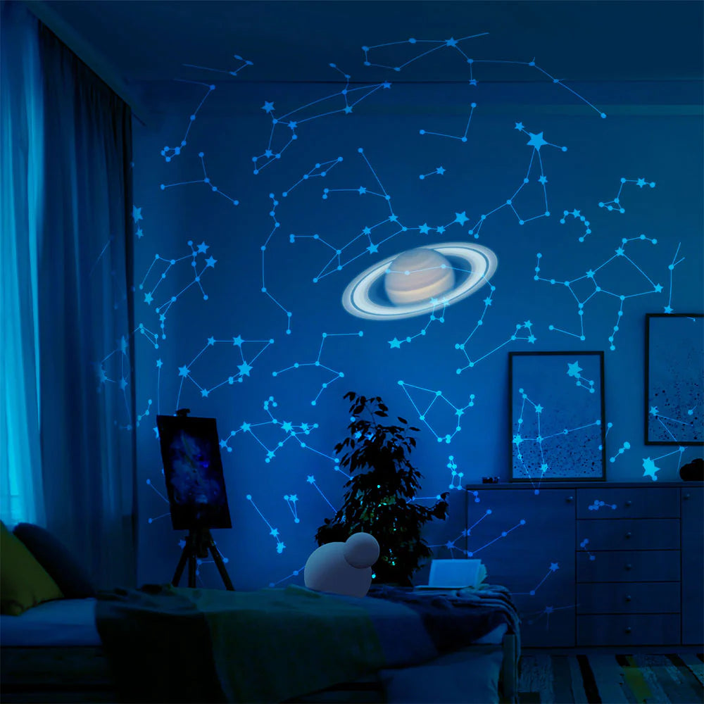 Planetarium Style Galaxy Projector illuminating a room with star patterns and a Saturn projection on the wall.