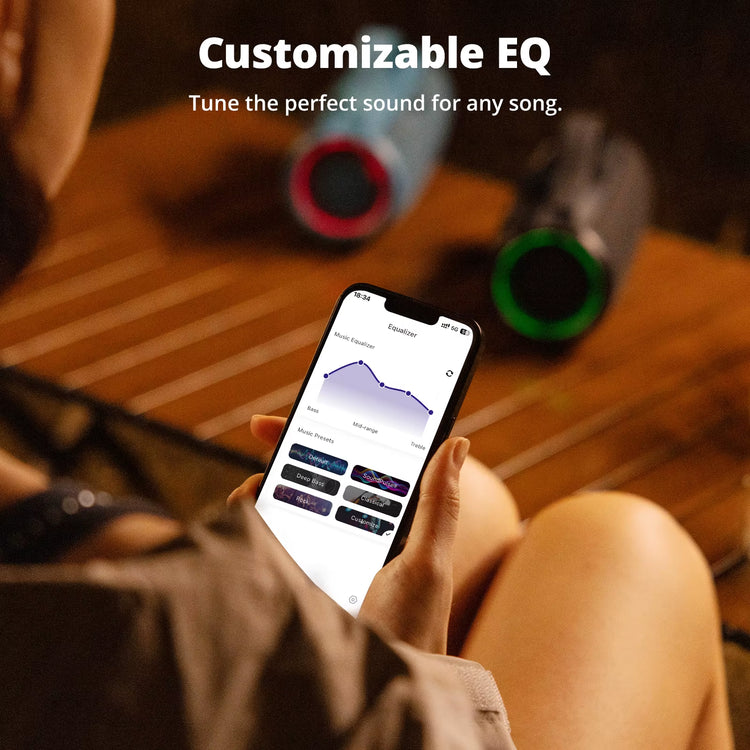 Person adjusting customizable EQ settings on a phone near Mirtune S100 Bluetooth Speaker for enhanced sound.