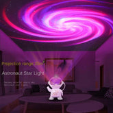 Astronaut Galaxy Projector creating a colorful starry sky projection on the ceiling in a cozy room.