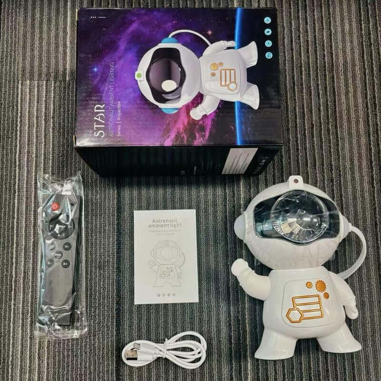 Astronaut Galaxy Projector with remote and user manual on a textured surface, creating a starry atmosphere.