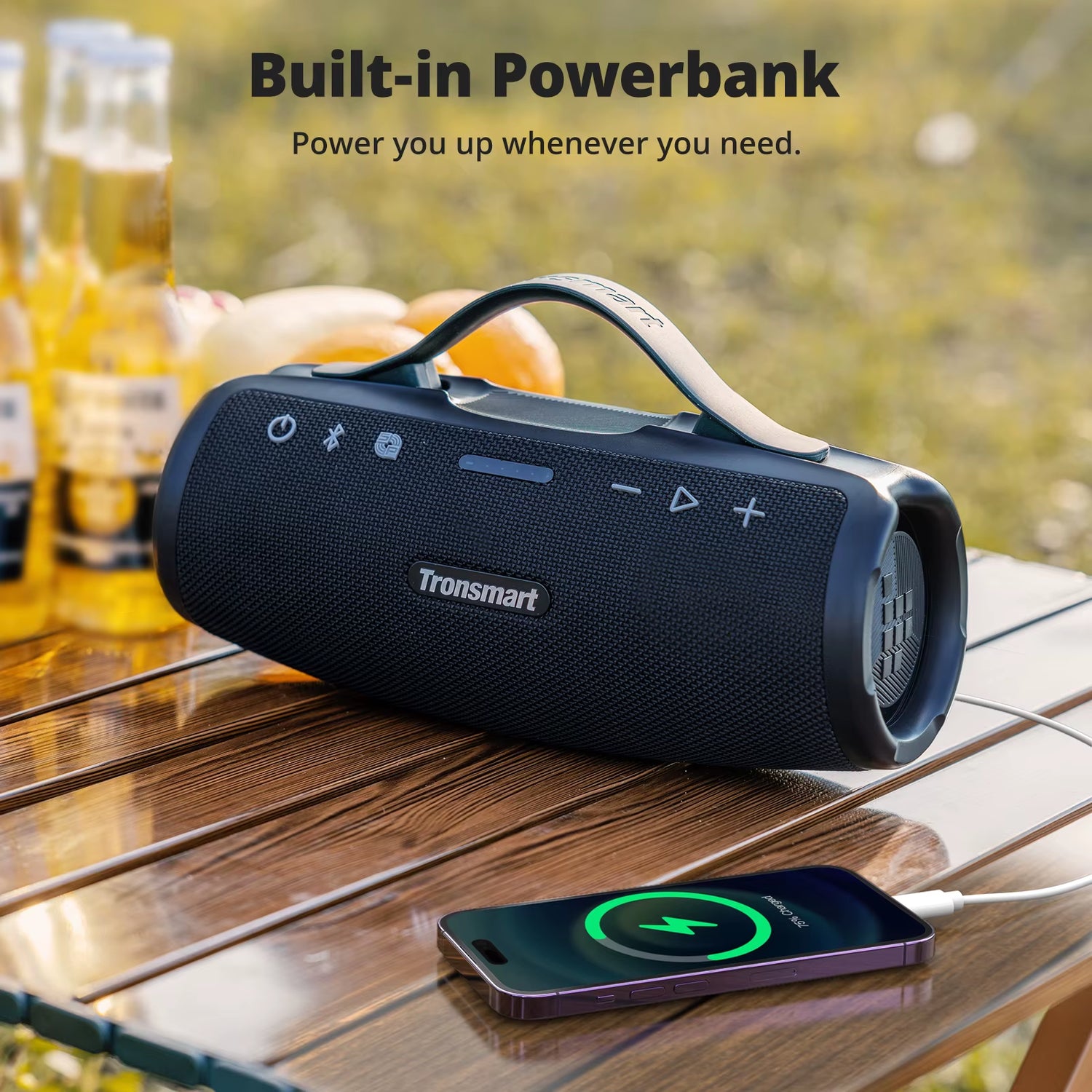 Mirtune S100 Bluetooth Speaker on a table with a power bank, ideal for outdoor gatherings.