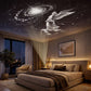 An elegant white angel and swirl galaxy constellation slide projected onto a dark bedroom ceiling.