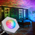 Aurora Wave LED Nebula Projector creating a colorful galaxy night light in a cozy room.